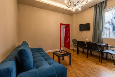 a living room with a blue couch and a table at Elegant 2bdr Apartment with a Balcony in Sofia