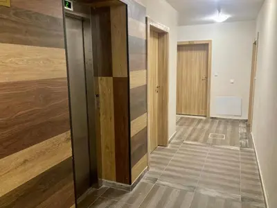 an empty hallway with wooden walls and a door at Cactus Apartment in Borovets