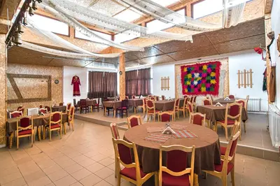 a dining room with tables and chairs and a painting at Kamena Pamporovo in Pamporovo