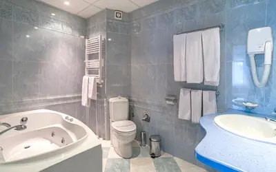 a bathroom with a tub and a toilet and a sink at Kamena Pamporovo in Pamporovo