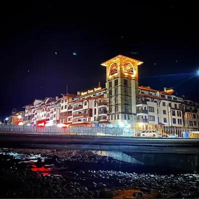 a large building with a clock tower in front of it at Finest Luxury Penthouse Bansko Royal Towers in Bansko