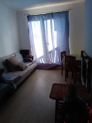 a living room with a couch and a large window at Синьо небе in Bansko