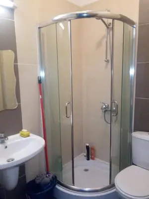 a bathroom with a shower and a toilet and a sink at Синьо небе in Bansko