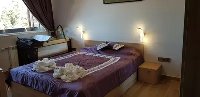 a bedroom with a purple bed with two white flowers on it at Lovely Аpartment in IGLIKA 2,Borovets in Borovets