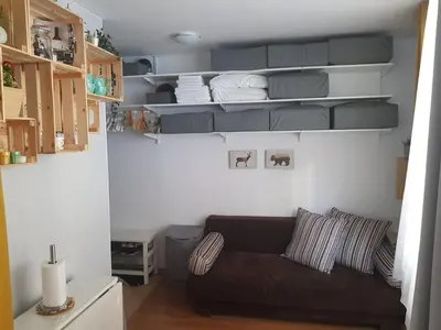 a living room with a couch and shelves at Gondola studio ENA in Bansko
