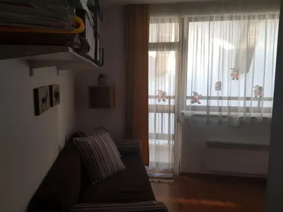 a living room with a couch and a window at Gondola studio ENA in Bansko