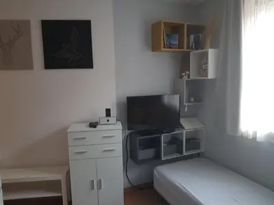 a bedroom with a bed and a desk with a television at Gondola studio ENA in Bansko