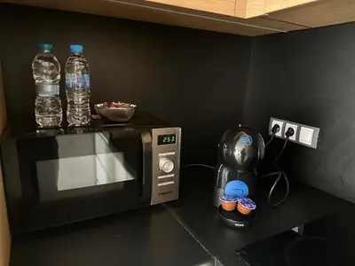 a kitchen with a microwave and two bottles of water at Silver city Paradise in Sofia