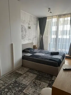 a bedroom with a bed and a desk and window at Silver city Paradise in Sofia