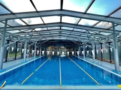 a large swimming pool with blue water in a building at Silver city Paradise in Sofia