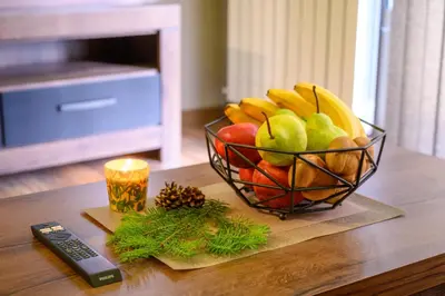 a bowl of fruit on a table with a remote control at The White Horse Apartments in Borovets