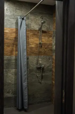 a shower with a shower curtain in a bathroom at The White Horse Apartments in Borovets
