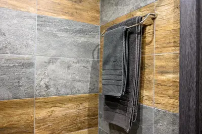 a bathroom with a black shutter on a wall at The White Horse Apartments in Borovets