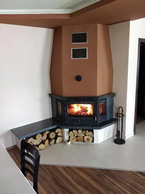 a fireplace in a living room with logs at Sveti Nikola Villas near Borovets in Shiroki Dol