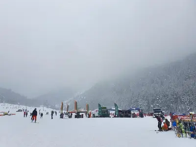 a group of people standing on a snow covered slope at Spacious and Cosy Apartment in Bansko Royal Towers Complex in Bansko