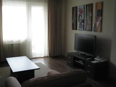 a living room with a tv and a chair at Spacious and Cosy Apartment in Bansko Royal Towers Complex in Bansko