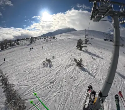 a group of people skiing down a snow covered slope at Relax&Ski apartment in Bansko