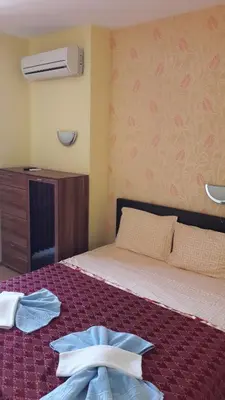 a bedroom with a bed with a robe on it at Apartament Fantasy Hisarya in Hisarya
