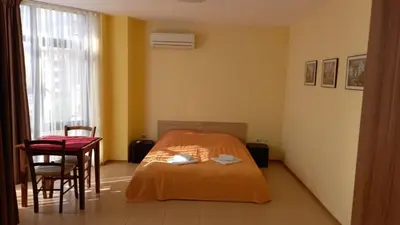 a bedroom with a bed and a table and chairs at Apartament Fantasy Hisarya in Hisarya