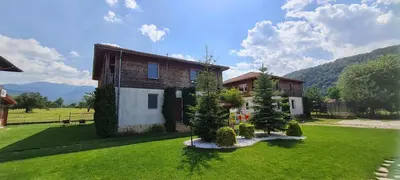 a house on a green lawn with trees in the yard at Villa Nikol Apt #1 in Raduil