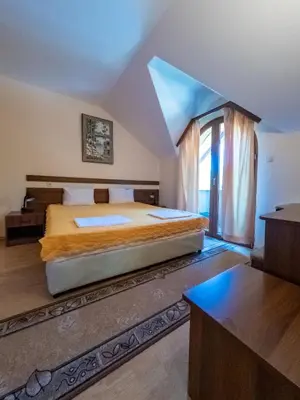 a bedroom with a large bed and a window at Почивна база 