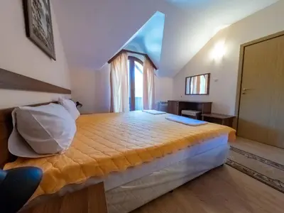 a bedroom with a large bed with a window at Почивна база 