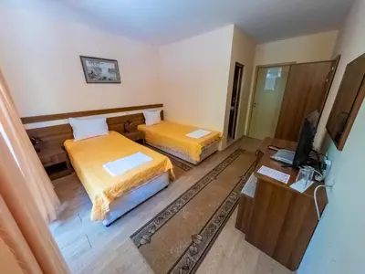 two beds in a small room with a television at Почивна база 