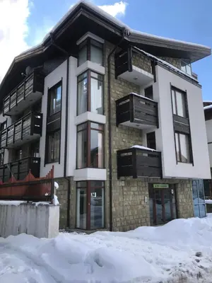 a building with snow in front of it at Marina Apartments - One Bedroom in Bansko