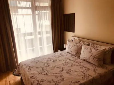 a bedroom with a bed with a white bedspread and a window at Marina Apartments - One Bedroom in Bansko