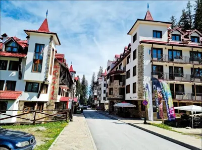 a street in a town with buildings with red roofs at Apartment in Castle 1 in Pamporovo