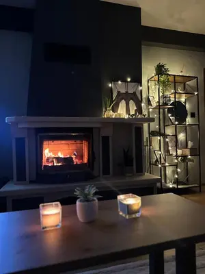 a fireplace in a living room with a table and candles at Apartment in Castle 1 in Pamporovo