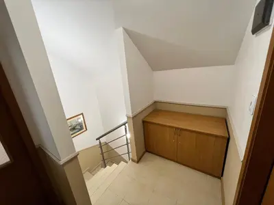 an attic room with a staircase and a wooden cabinet at Мезонет Лапландия in Pamporovo