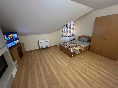 a bedroom with a bed and a flat screen tv at Мезонет Лапландия in Pamporovo