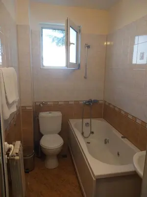 a bathroom with a toilet and a tub and a sink at Hotel Tsarevets in Asenovgrad