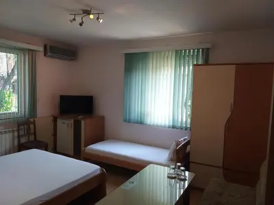 a small room with a bed and a tv at Hotel Tsarevets in Asenovgrad
