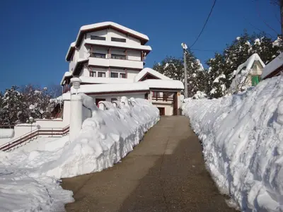 a fence covered in snow next to a building at Family Hotel Diana in Lyaskovo