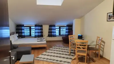 a living room with a couch and a table and chairs at Studio GERONIMO in Pamporovo