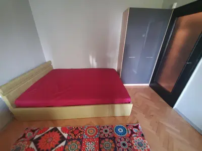 a bed sitting in a room with a rug at Романтично Място Ани in Plovdiv