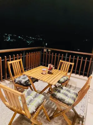 a wooden table and two chairs on a balcony at Ani's Guest House in Chepelare