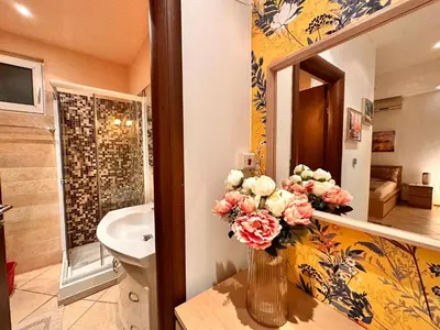 a bathroom with a sink and a vase of flowers at Private Studio Center Opera and Nevski Cathedral in Sofia