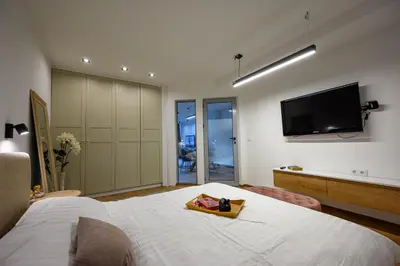 a bedroom with a bed and a flat screen tv at Гардън Апарт in Blagoevgrad