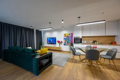 a living room with a green couch and a table at Гардън Апарт in Blagoevgrad
