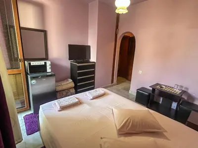 a bedroom with a bed with a television and a dresser at Hotel Darling in Bankya