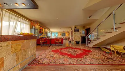 a living room with a staircase and a red rug at Hotel FAMIL - adults only in Bansko