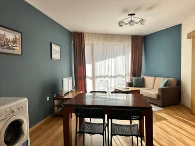 a kitchen and living room with a table and chairs at Pirin place private apartment in Bansko