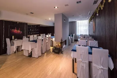 a dining room with white tables and white chairs at Dinos 2 Bed Cozy Apart at Bansko close to the lift in Bansko