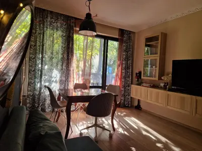 a living room with a table and chairs and a window at Homey art apartment next to Drujba lake Metro stations and bul.Tsarigradsko Shose in Sofia