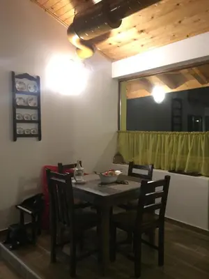 a dining room with a table and chairs and a mirror at Вила Ренесанс Костенец in Kostenets Village