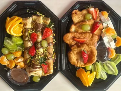 two black plastic containers filled with food and fruit at HIDDEN BANK: First Million in Plovdiv