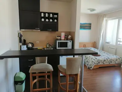 a kitchen with a table and chairs and a bed at Bansko Royal Towers T&K in Bansko